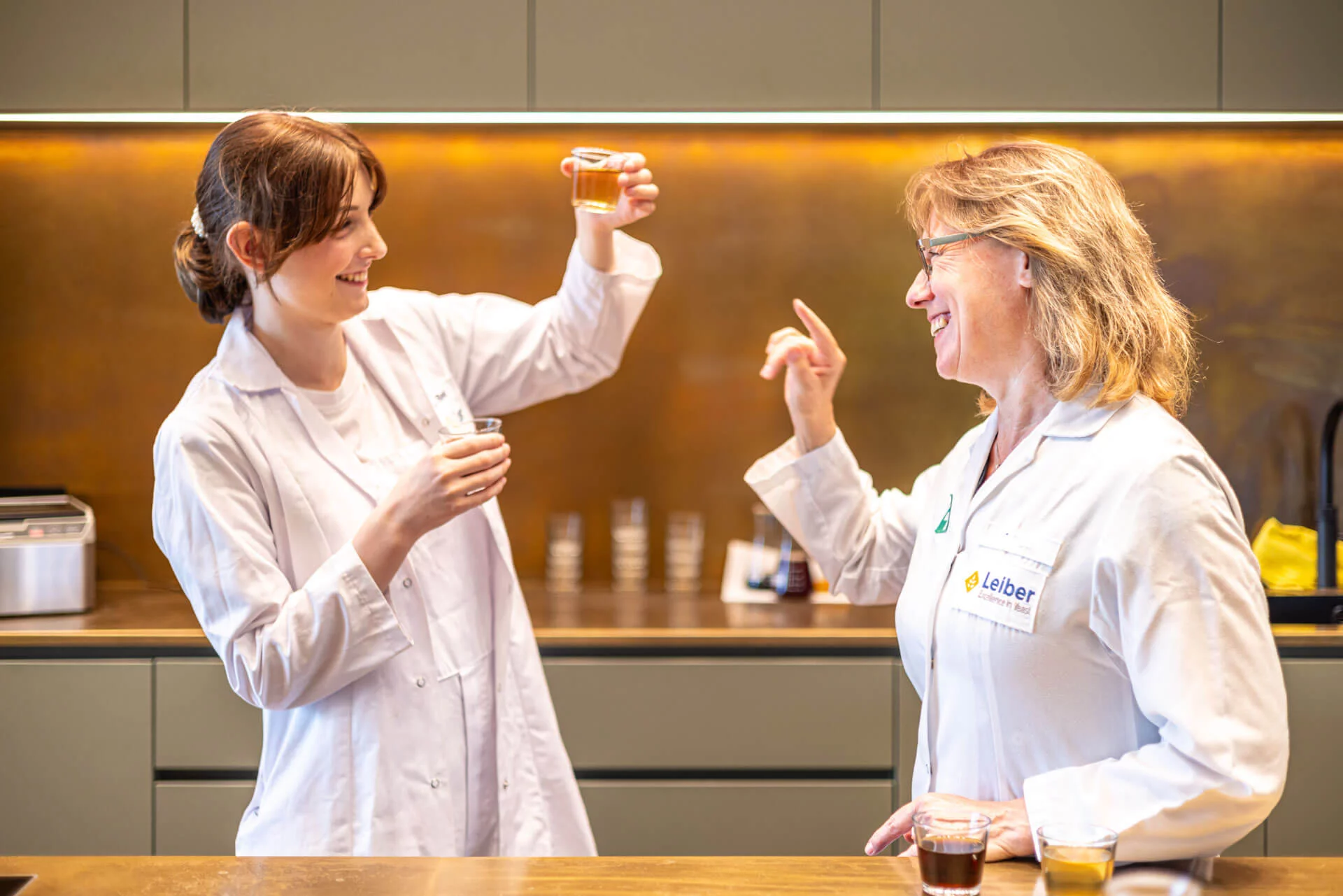 Testkueche – Auszubildende und Ausbilderin mit Proben