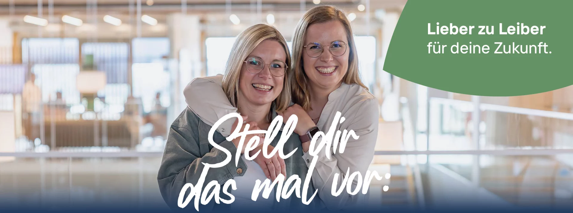 Zwei junge Frauen im Büro kumpelig umarmt